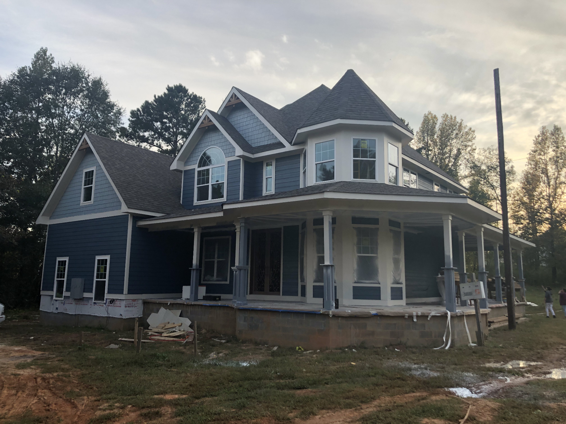 Front elevation of the completed blue custom home with turret and covered porch